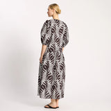 Woman wearing a black and white patterned dress on a white background