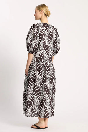 Woman wearing a black and white patterned dress on a white background