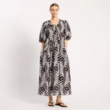 Woman wearing a black and white patterned dress on a white background