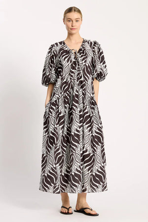 Woman wearing a black and white patterned dress on a white background