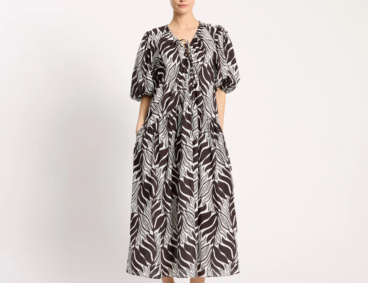 Woman wearing a black and white patterned dress on a white background