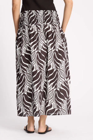 Person wearing a zebra print skirt on a white background