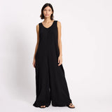 Woman wearing a black sleeveless jumpsuit on a white background