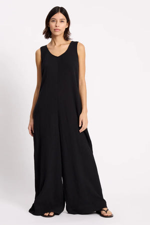 Woman wearing a black sleeveless jumpsuit on a white background