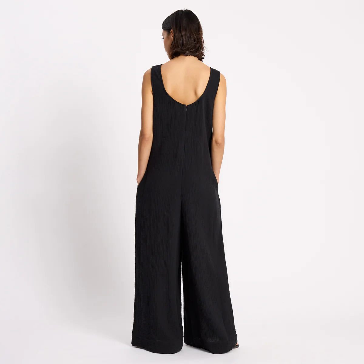 Person wearing a black jumpsuit on a white background