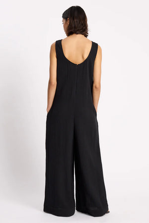 Person wearing a black jumpsuit on a white background