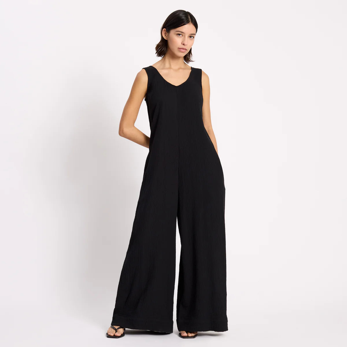 Woman wearing a black jumpsuit on a white background