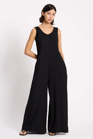 Woman wearing a black jumpsuit on a white background