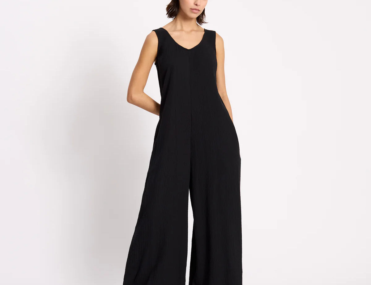 Woman wearing a black jumpsuit on a white background