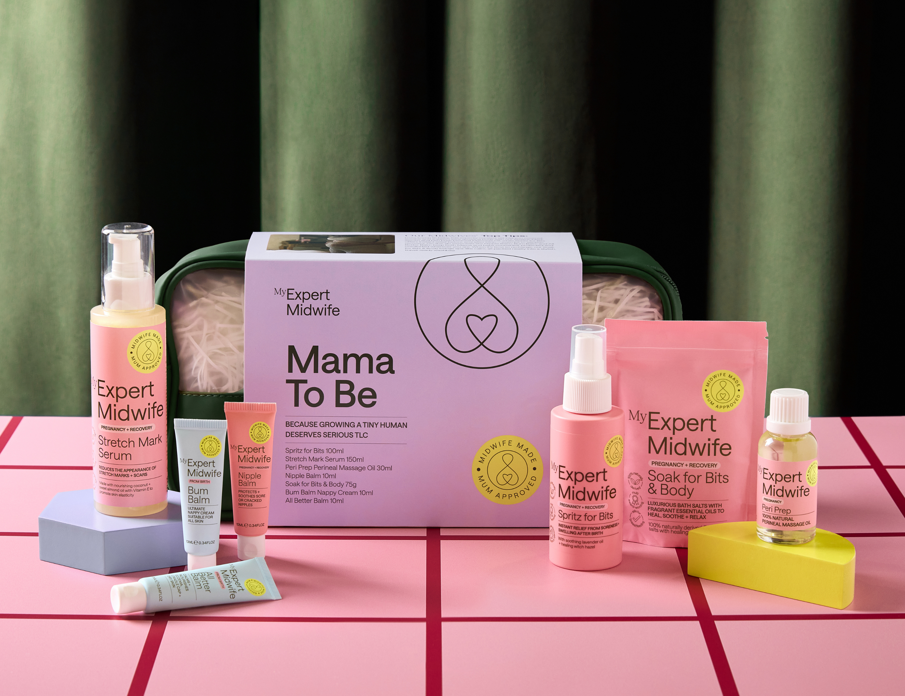 Collection of 'My Expert Midwife' skincare products on a pink grid background