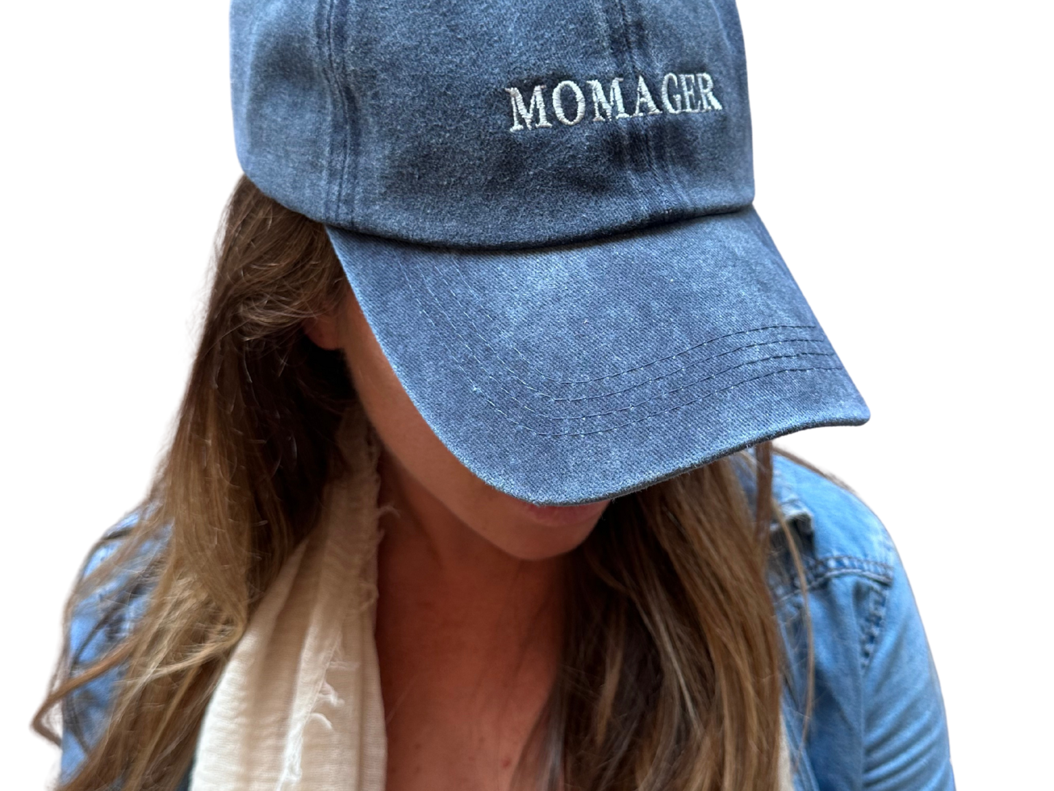 A person wearing a blue denim baseball cap with the word 'MOMAGER' embroidered in white on the front, shown against a plain white background.