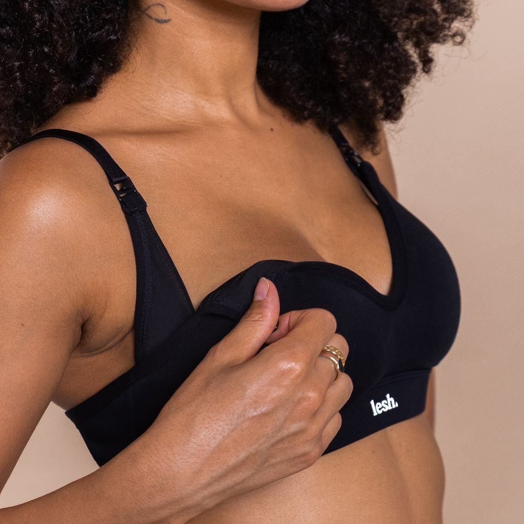 Person wearing a black bra with 'lesh' branding on a beige background