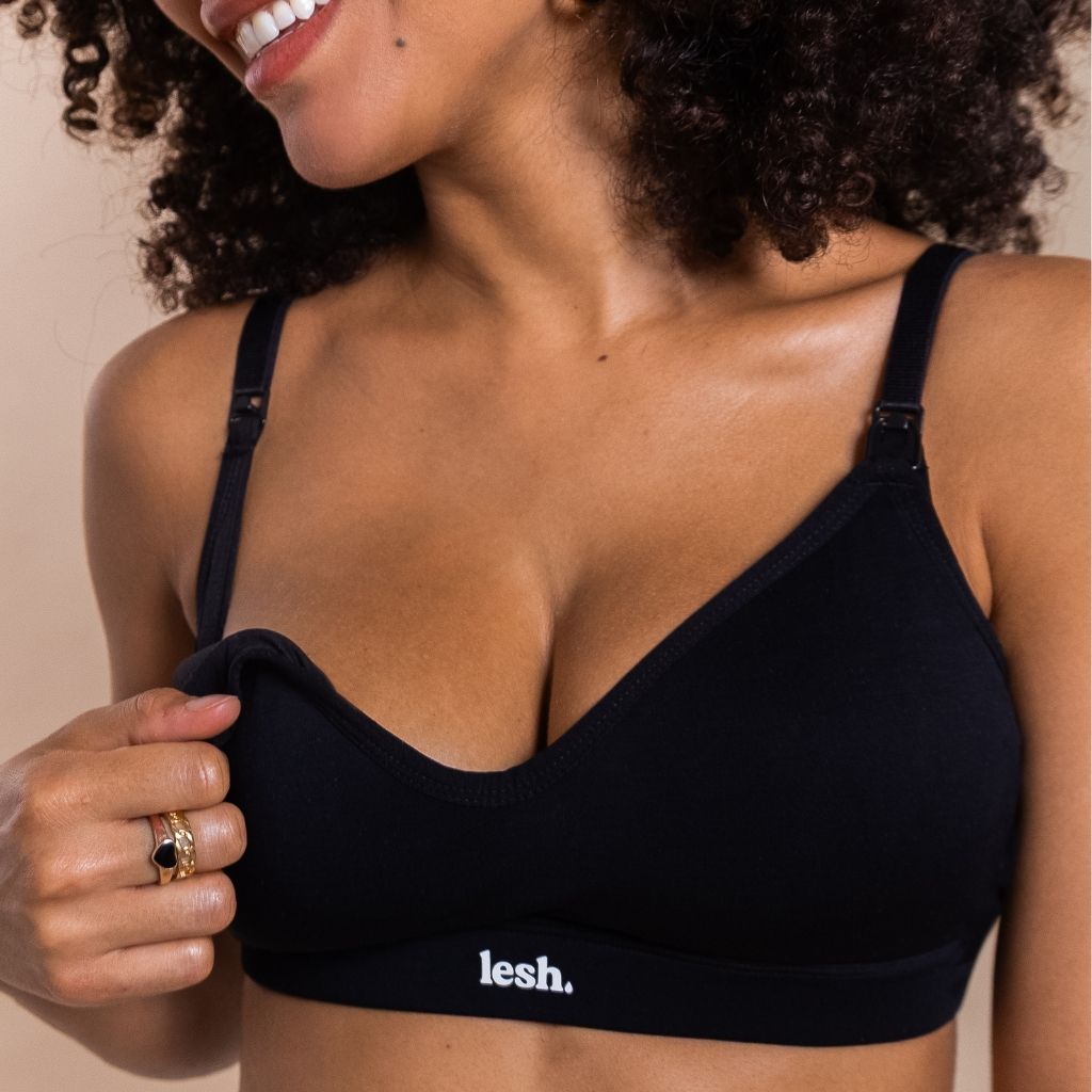 Woman wearing a black bralette with 'lesh' branding on a beige background