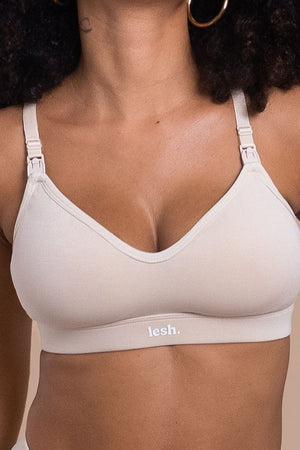 Woman wearing a beige bra with 'lesh' branding on a beige background