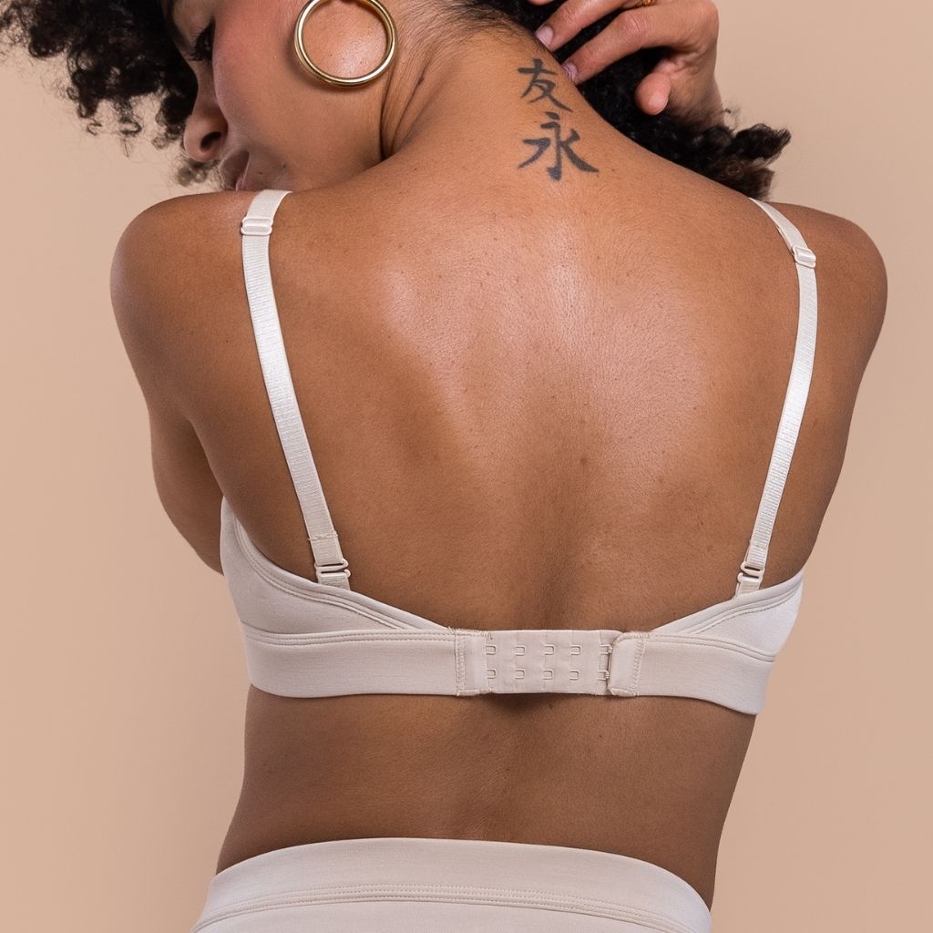Woman wearing a beige bra with a neutral background