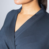 Navy blue top worn by a person against a light gray background