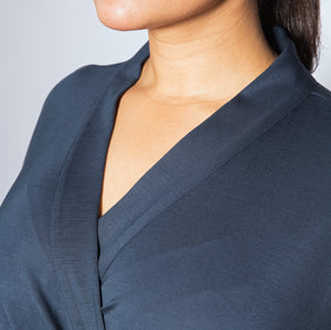 Navy blue top worn by a person against a light gray background