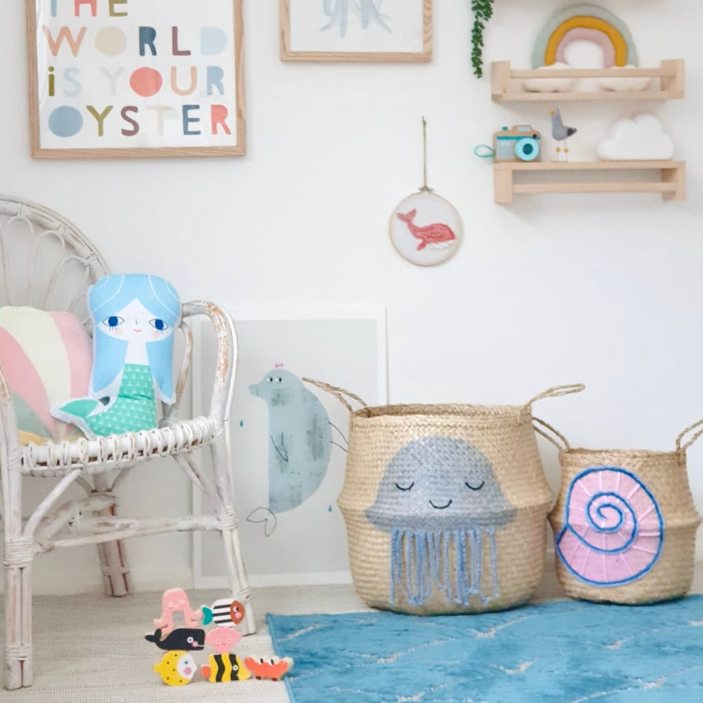 Shell belly basket, large, beside a jellyfish basket in a child's room with a mermaid cushion and toy sea animals