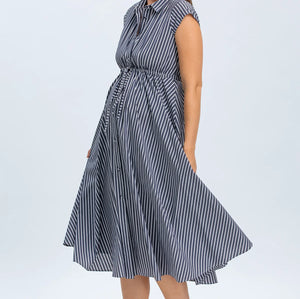 Woman wearing a blue and white striped dress on a light gray background