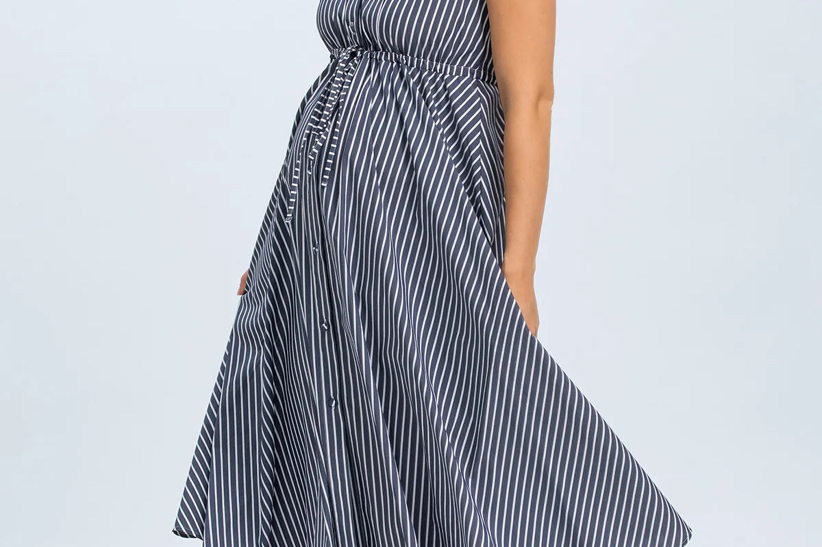 Woman wearing a blue and white striped dress on a light gray background