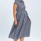 Woman wearing a blue and white striped dress on a light gray background
