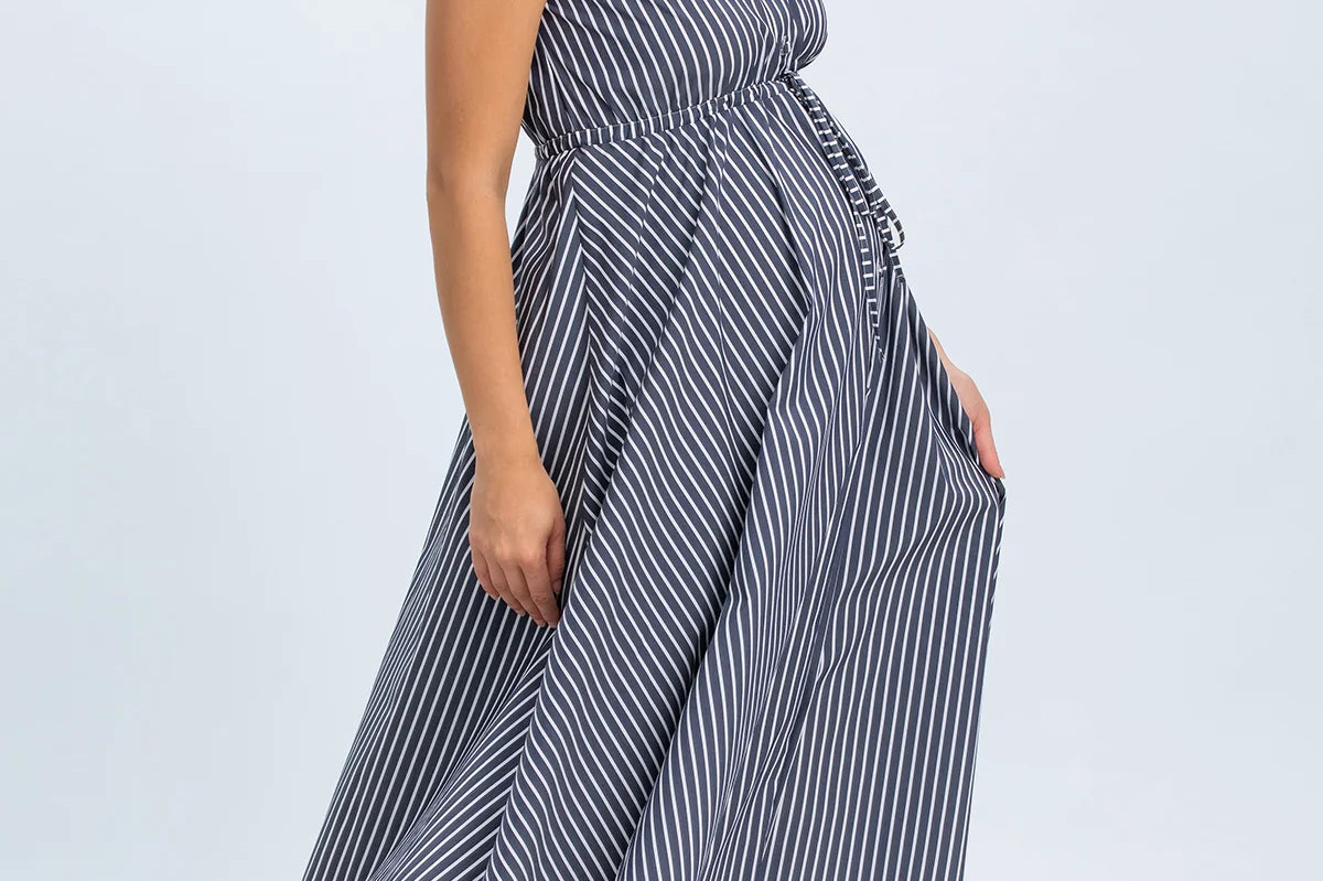 Woman wearing a blue and white striped dress on a light gray background