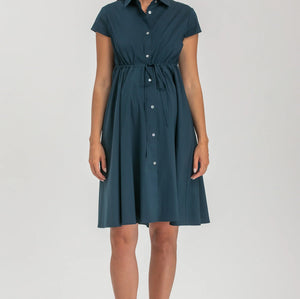 Woman wearing a teal dress with a belt on a white background