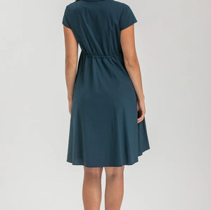 Pregnant woman wearing navy blue shirt dress on grey background