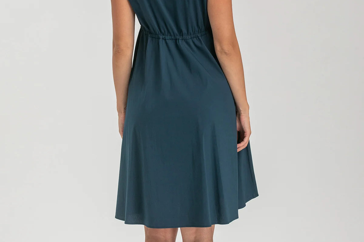 Pregnant woman wearing navy blue shirt dress on grey background