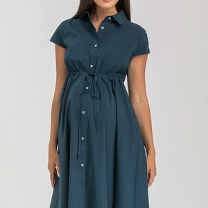 Pregnant woman wearing navy blue shirt dress on grey background