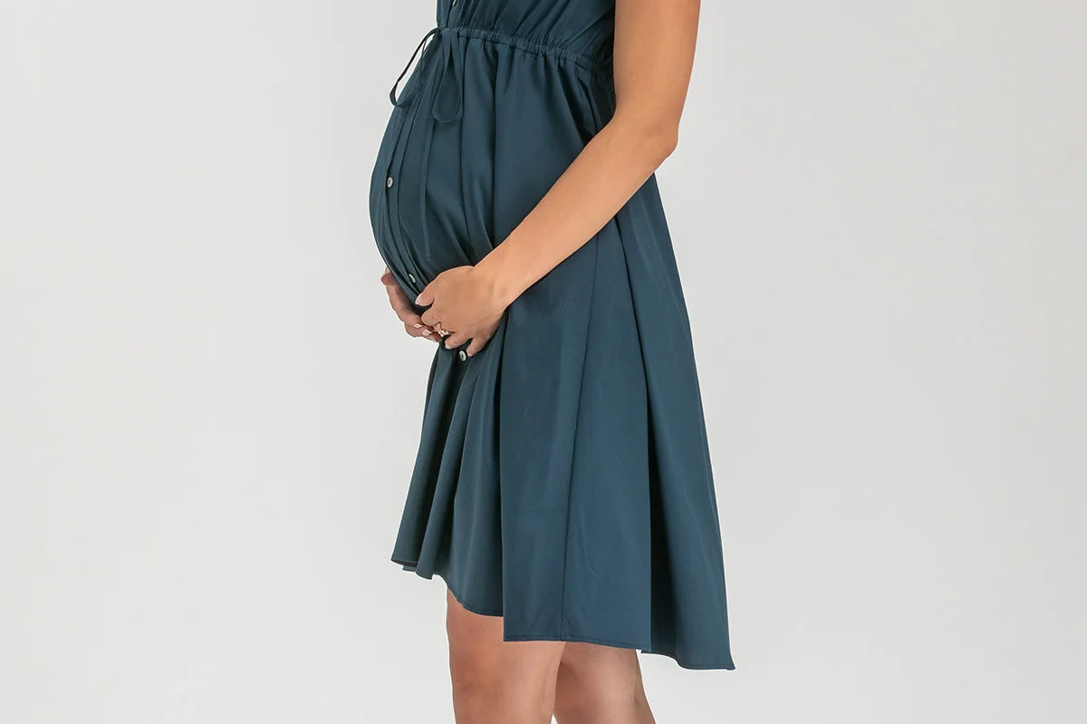 Woman wearing a teal dress on a white background