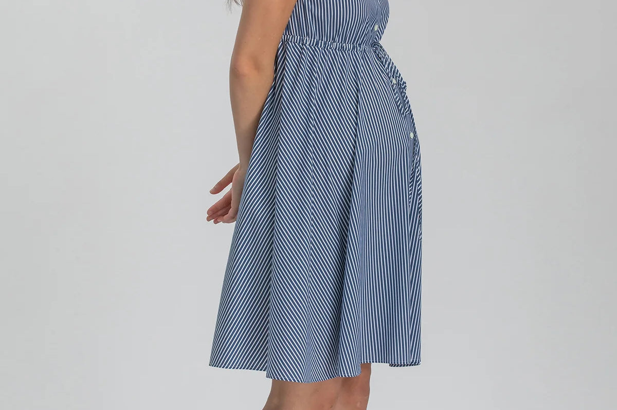 Woman wearing blue stripe shirt dress on grey background