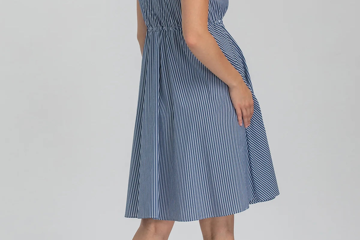 Woman wearing a blue striped dress on a white background