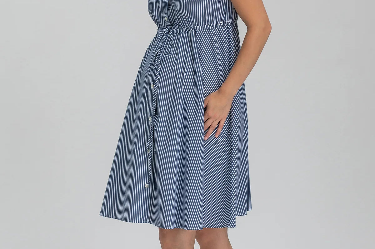 Woman wearing a blue striped dress on a gray background