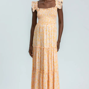 Woman wearing a yellow patterned dress on a white background