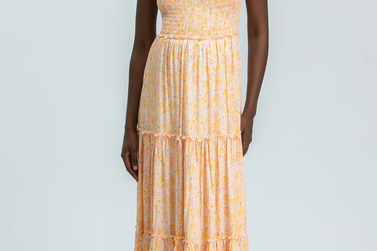 Woman wearing a yellow patterned dress on a white background