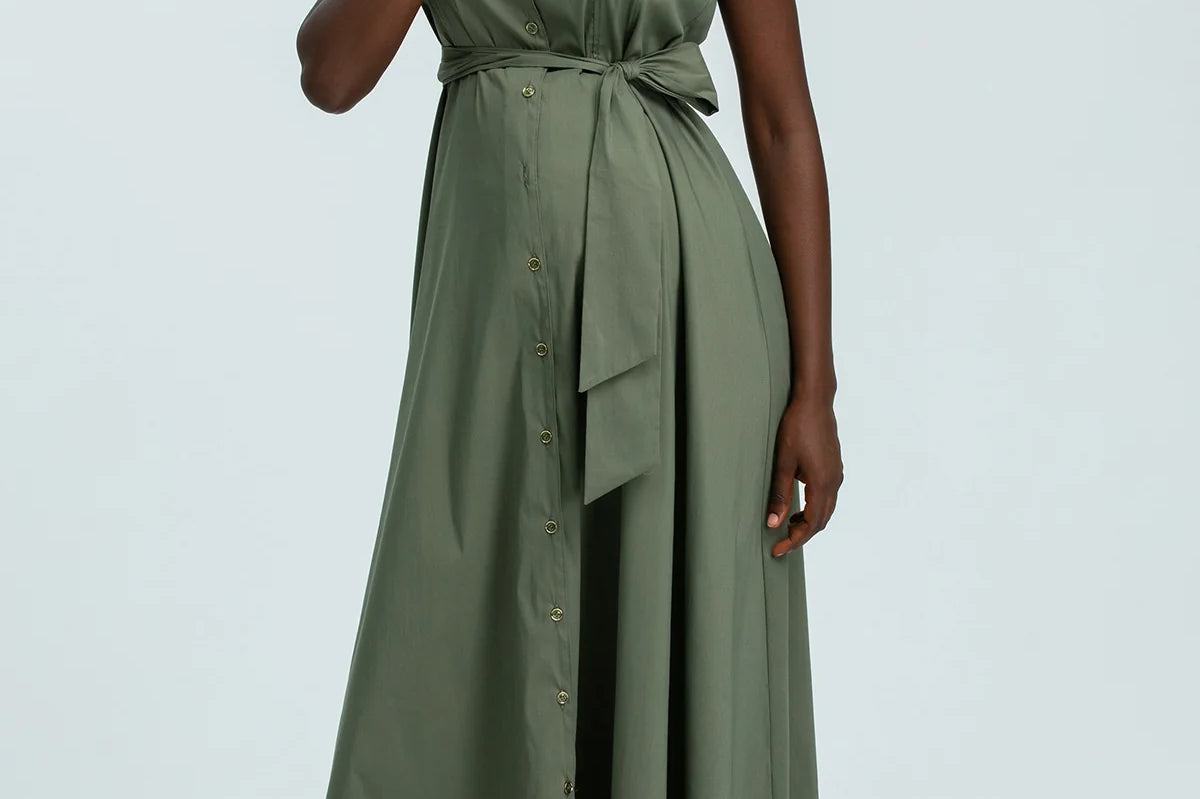 Woman wearing a green dress against a light gray background