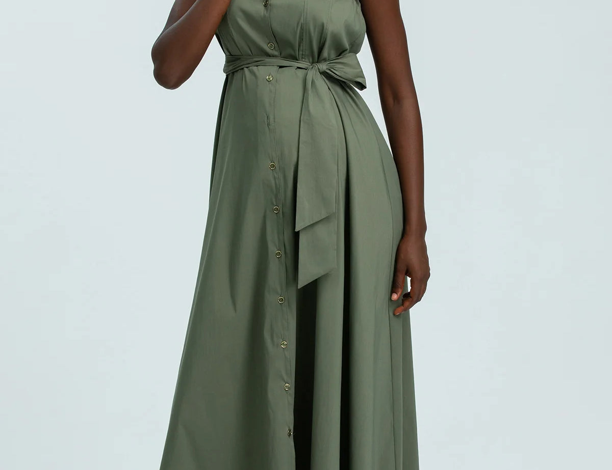 Woman wearing a green dress against a light gray background
