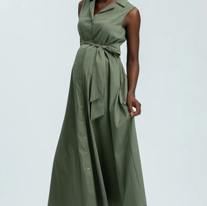 Woman wearing green sleeveless full length shirt dress on pale background