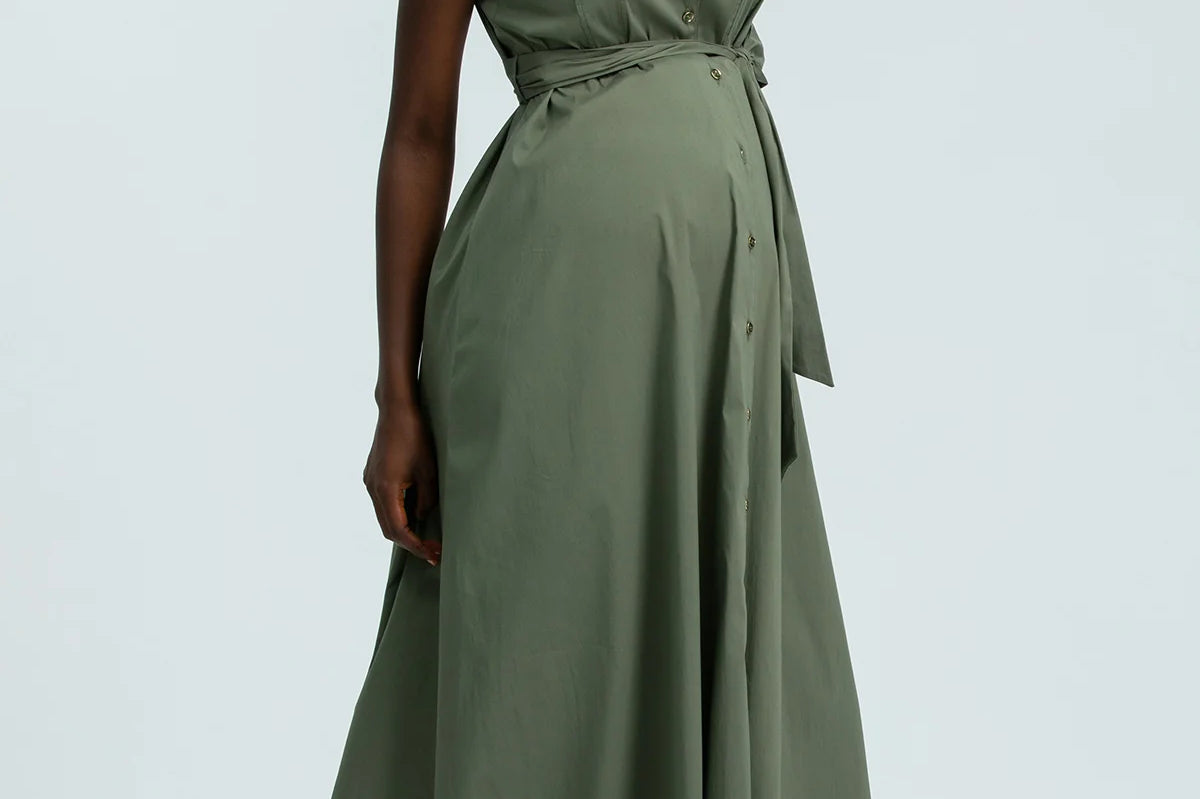 Woman wearing a green dress against a light gray background