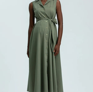 Woman wearing green sleeveless full length shirt dress on pale background