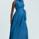 Woman wearing a blue sleeveless dress with buttons on a white background