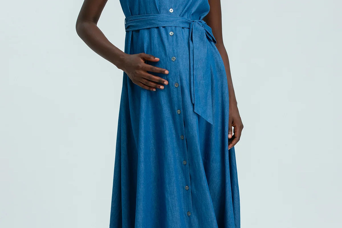 Woman wearing a blue sleeveless dress on a white background