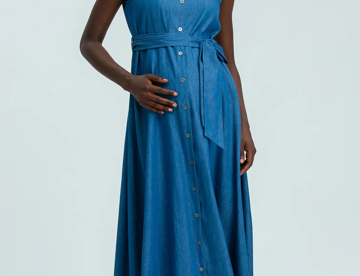 Woman wearing a blue sleeveless dress on a white background