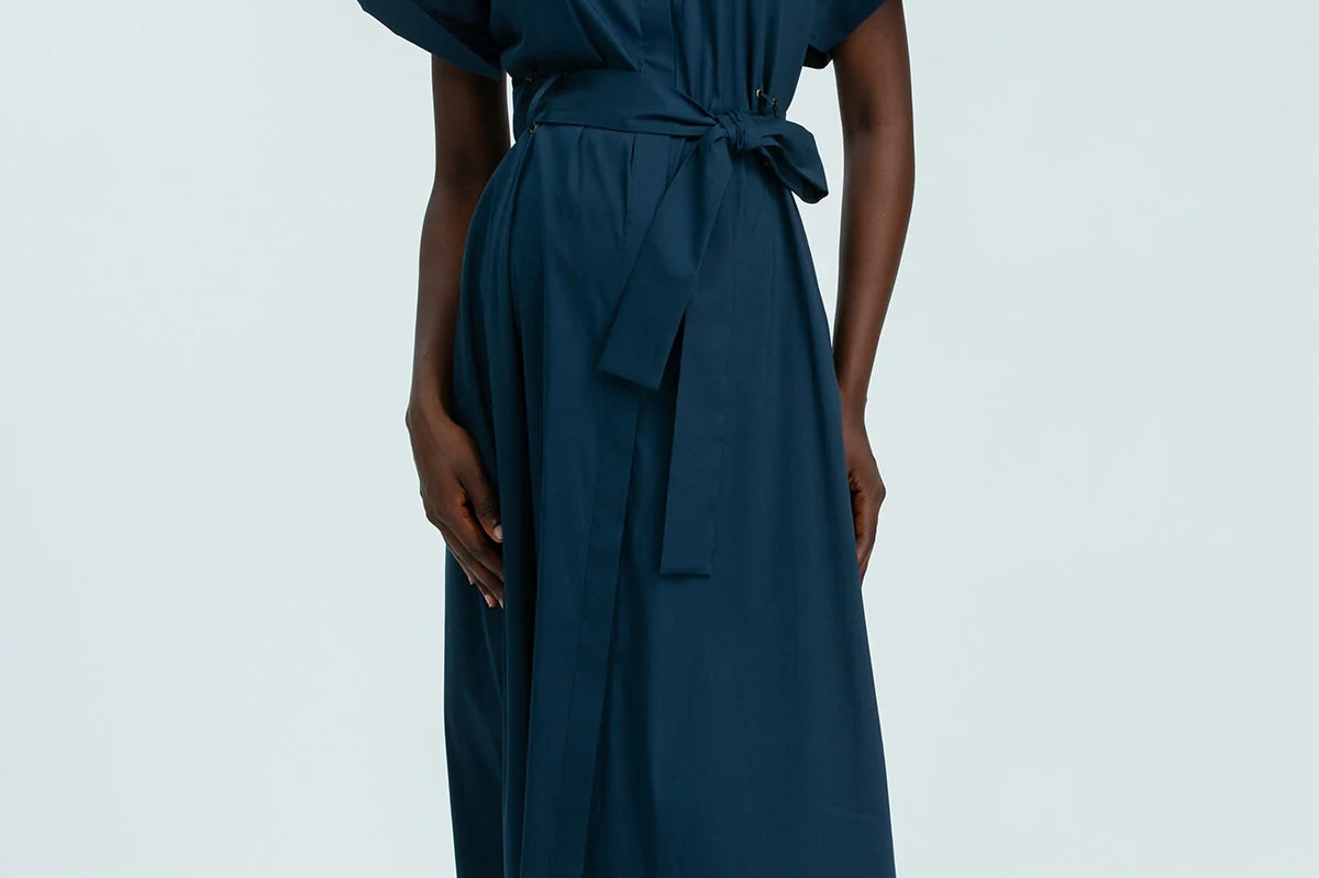 Person wearing a teal dress on a white background