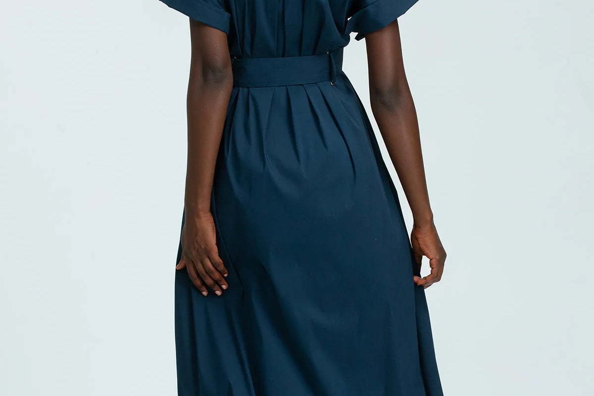 Person wearing a teal dress on a white background