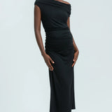 Woman wearing a black one-shoulder dress against a white background