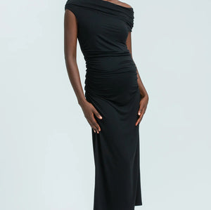 Woman wearing a black one-shoulder dress against a white background