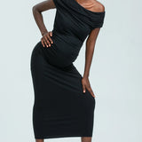 Woman wearing a black one-shoulder dress against a white background