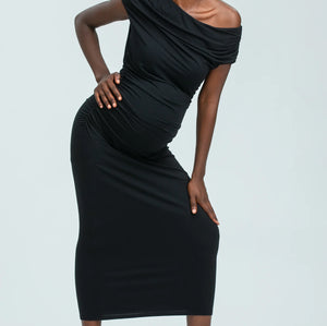 Woman wearing a black one-shoulder dress against a white background